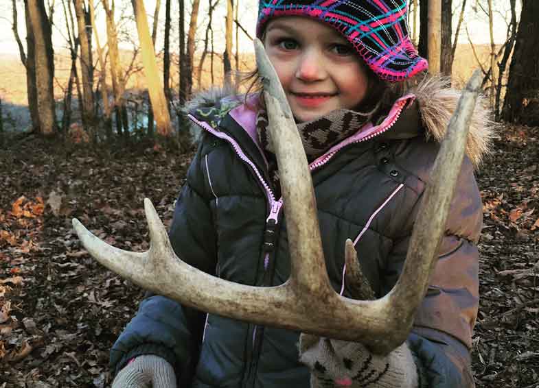 Girl holding shed deer antlers