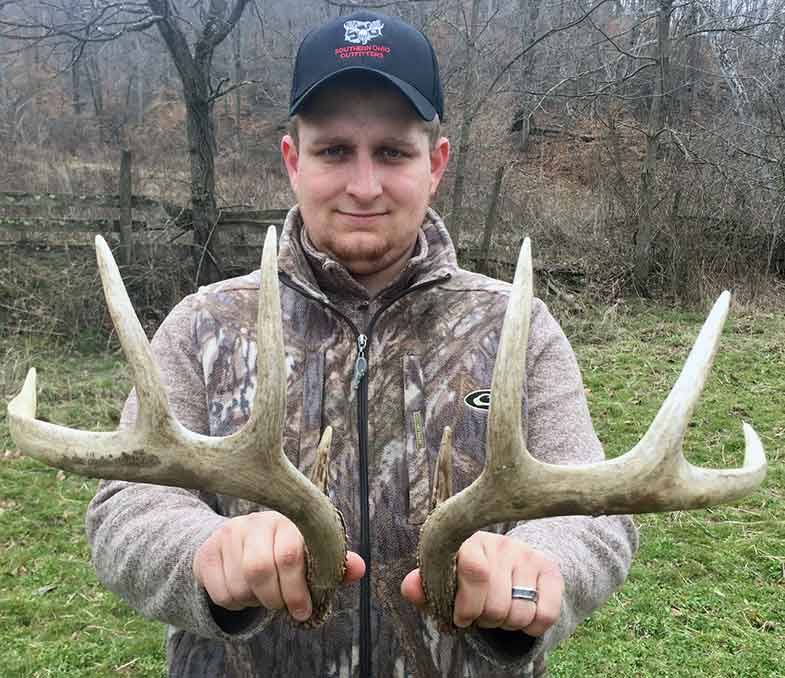 Man holding shed deer antlers