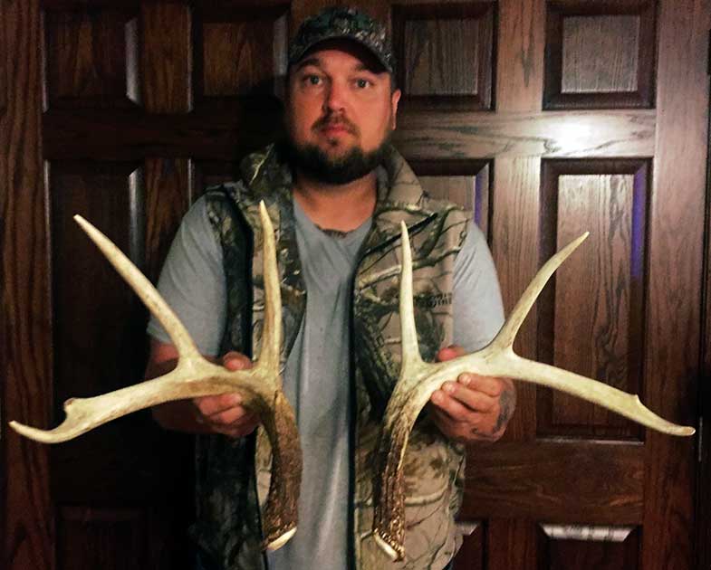 Man holding shed deer antlers